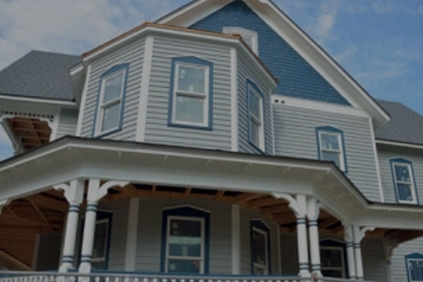 front of a blue house with a wrap-around porch